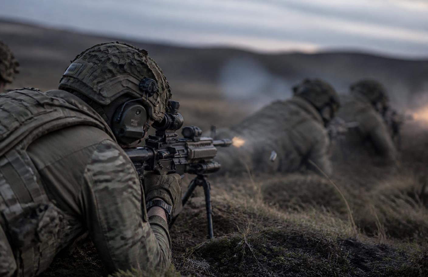 British Army soldiers firing on a live range wearing ear defenders